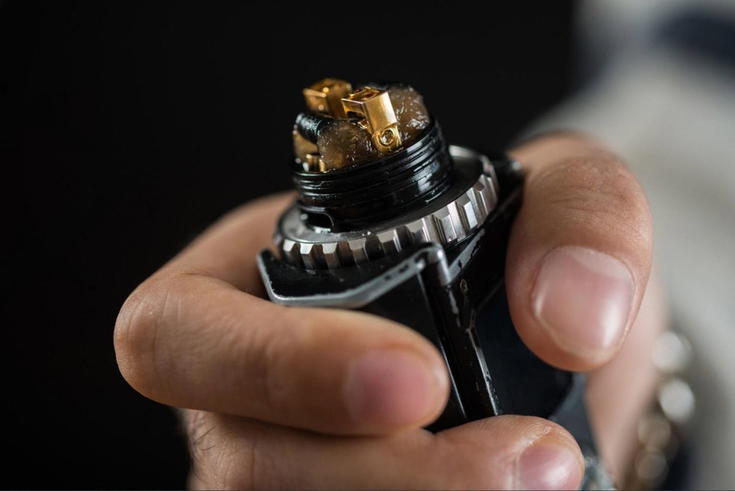 Close-up of a vape coil saturated with e-liquid held in a hand